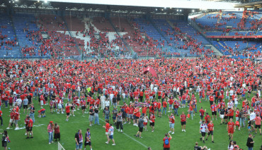 kibice wisły cieszący się na murawie stadionu przy reymonta