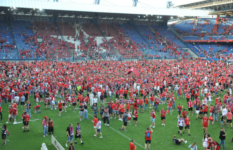 kibice wisły cieszący się na murawie stadionu przy reymonta